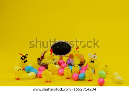 happy aester hatching chickens on a yellow background, with glasses in a nest, on a yellow background with place for inscription happy easter