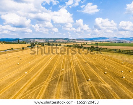 Bales of hay on the field after harvest shot by drone
