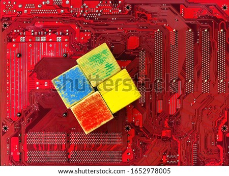 Old and shabby children's cubes are laid out on a background of motherboard. The problem of an outdated PC operating system and the need to update it.