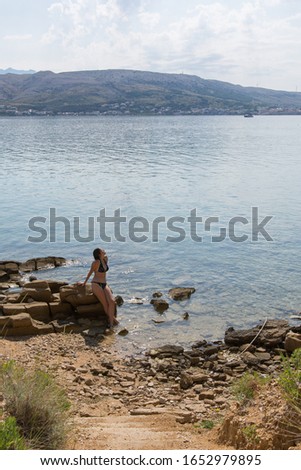 A girl on a rocky seashore. Shoot on the Adriatic Sea, Pag in Croatia.