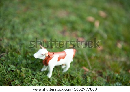 
Toy cow on green grass background