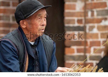 The old man is weaving a bamboo basket Royalty-Free Stock Photo #1653062353