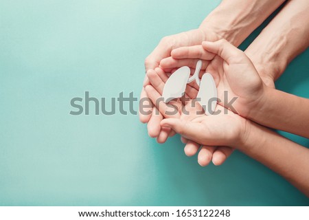 Adult and child hands holding lung, world tuberculosis day, world no tobacco day, lung cancer,  Pulmonary hypertension, Pneumonia, copd, eco air pollution,organ donation, respiratory and chest concept Royalty-Free Stock Photo #1653122248