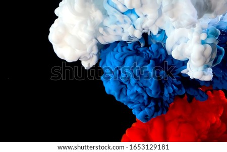 Flag of Russia made of colored ink on a black background. White, blue and red watercolor ink in water. A powerful explosion of colors. Stylish trending screensaver.