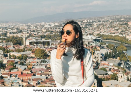 Asian woman tourist is taking selfie of herself with landscape view of Tbilisi city from the moutain in Georgia.