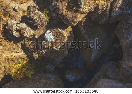 Woman in lush mint dress in Aksu canyon in south Kazakhstan aerial view. Young woman in fairy tale ball gown on background of rocks and mountains. Beautiful girl in long airy dress in mountainous area