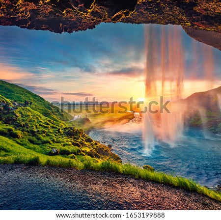 Great sunset on popular tourist destination - Seljalandsfoss waterfall, where tourists can walk behind the falling waters. Impressive summer scene of Iceland. Beauty of nature concept background.