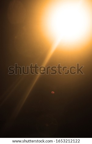 Flash of a distant abstract star. Abstract sun flare. The lens flare is subject to digital correction. - Image toned