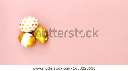 Trendy white golden spring easter eggs flat lay on colorful pink background top view with copy space. Hand painted eggs. Happy easter day celebration concept. Web banner template. Stock photo.