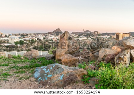 city on the top of mountains rocks and sunrise in the background 