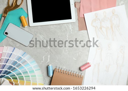 Flat lay composition with tablet, smartphone and color palette on grey marble table, space for text. Designer's workplace