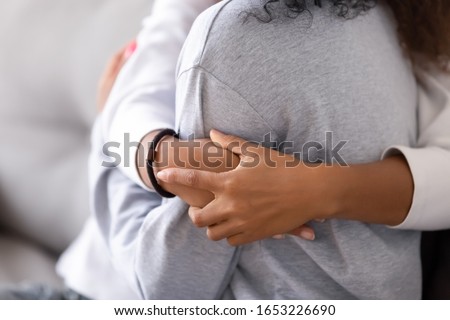 Loving african american foster care parent single mother sister embrace teen daughter giving support and protection, black mom hug teenage girl, family kindness concept, close up view, focus on hands Royalty-Free Stock Photo #1653226690