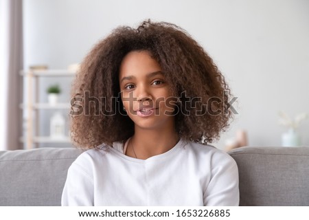 Pretty african teen girl vlogger speaking by video call blog looking at webcam, adolescent teenage blogger talking to camera recording vlog for channel student study online, headshot portrait Royalty-Free Stock Photo #1653226885
