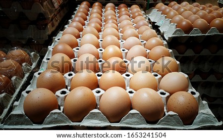 Fresh chicken eggs pile up on the tray at supermarket.