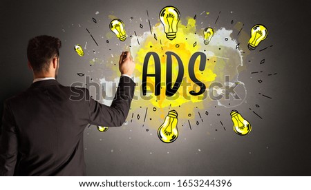 businessman drawing colorful light bulb with ADS abbreviation, new technology idea concept