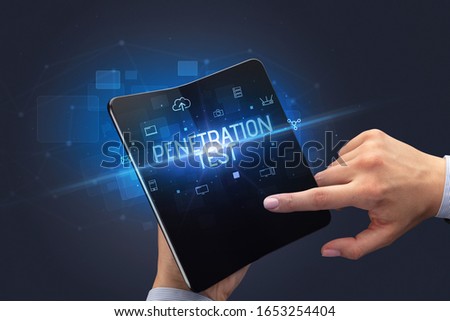Businessman holding a foldable smartphone with PENETRATION TEST inscription, cyber security concept Royalty-Free Stock Photo #1653254404