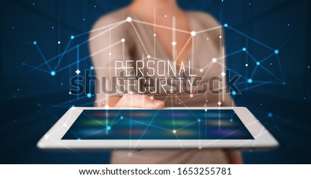 Young business person working on tablet and shows the digital sign: PERSONAL SECURITY