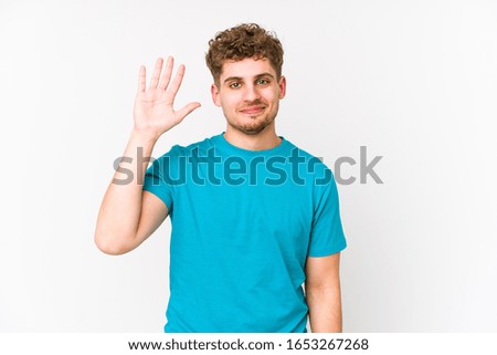 Young blond curly hair caucasian man isolated smiling cheerful showing number five with fingers.