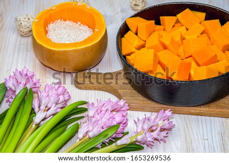 Pumpkin in pan and rice on table  .  Prepare food from pumpkin . Food for a healthy lifestyle , rural kitchen