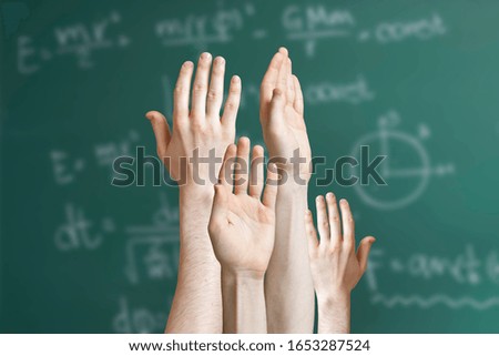 group of pupil raise hand and want to answer the teachers question, blackboard background