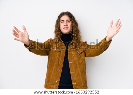 Long hair man posing isolated feels confident giving a hug to the camera.