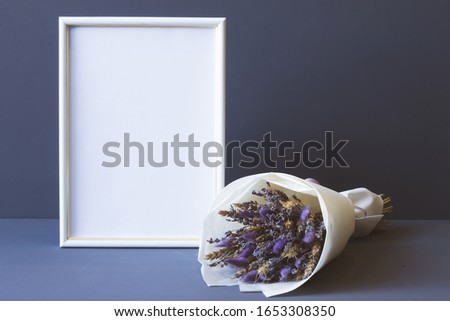 composition of dried flowers and a photo frame on a gray background copy space