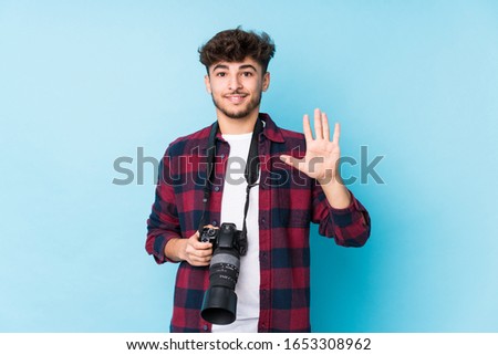 Young arab photographer man isolated smiling cheerful showing number five with fingers.