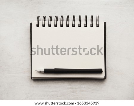 Notepad lying on a wooden table. Close-up, view from above, wooden surface. Concept of preparation for a professional holiday. Congratulations for relatives, friends and colleagues