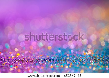 Decoration twinkle glitters background, abstract blurred backdrop with circles,modern design overlay with sparkling glimmers. Blue, purple and golden backdrop glittering sparks with glow effect