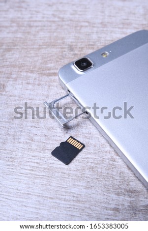 Flash memory data storage concept : A tray with a micro SD card on white background. A memory card is used for storing digital information in portable electronic devices e.g mobile phone, tablets