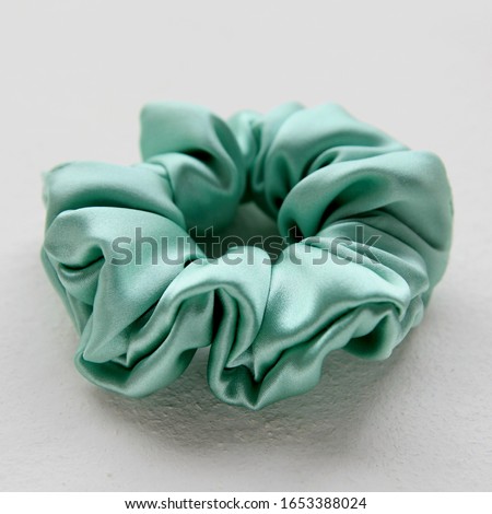 turquoise silk Scrunchy isolated on white background. Flat lay Hairdressing tool of Colorful Elastic Hair Band, Bobble Scrunchy Hairband Royalty-Free Stock Photo #1653388024