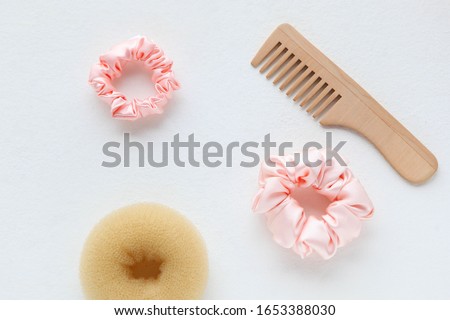 wooden Hairbrush, Doughnut and Pink Scrunchy isolated on white. Flat lay Hairdressing tools and accessories Color Hair Scrunchies, Elastic Hair Bands, Bobble Sports Scrunchy Hairband Royalty-Free Stock Photo #1653388030