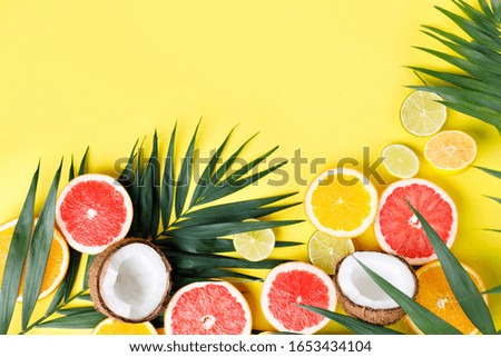 Summer holidays, resort vacation, exotic fruits background. Summertime vibes. Composition with citrus slices on yellow surface, copy space