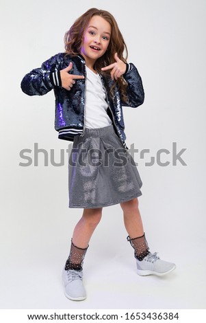 photo of a cool attractive teenager girl posing as a model on a white studio background