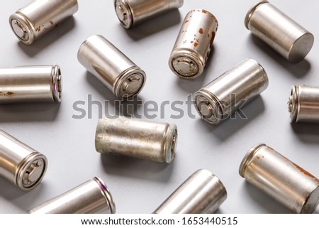 Close up of spent used rechargeable Nickel Metal Hydride (Ni-MH) battery on grey background, flat lay. Old Nickel-Cadmium (Ni-Cd) batteries without a protective shell with corrosion and rust Royalty-Free Stock Photo #1653440515