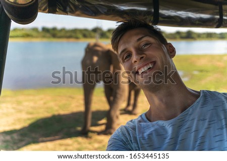 self portrait picture of a man during a safari in the wilderness. Elephant in the background