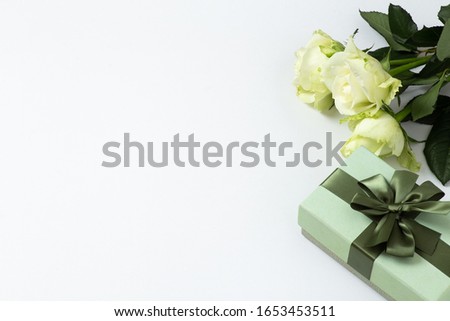 Lovely green roses and gift or present box with ribbon bow on white background. Copy space for text and product display.