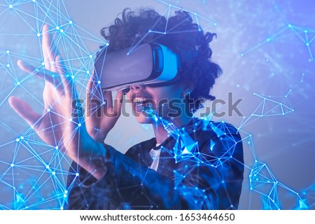 Amazed black female in modern VR glasses interacting with network while having virtual reality experience Royalty-Free Stock Photo #1653464650