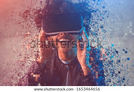 Happy African female in VR headset laughing and falling into particles while immersing into virtual reality