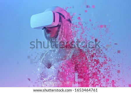 Young futuristic female in VR headset falling into particles while immersing into cyberspace under colorful neon light
