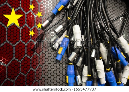 Wires with connectors and a Chinese flag. The concept of industrial China. The production of electrical goods on enterprises in China. Supplies of electrical equipment from China.