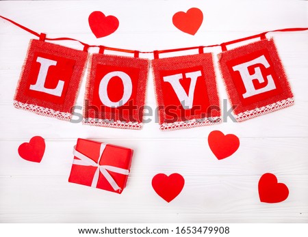 LOVE inscription with hearts and gifts on a wooden white background. Isolated on white background