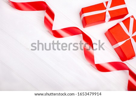 Red satin ribbon and box isolated on white background. The concept of the holidays