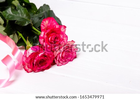 Roses and red ribbon isolated on white background. The concept of the holidays