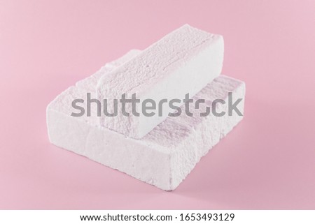 Sweet pink marshmallow rectangular shape in the form of a geometric shape. Marshmallows with the taste of cranberries, strawberries or other berries.