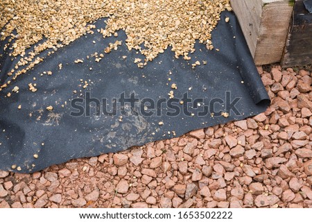Hard landscaping materials - aggregate, weed membrane and gravel used to lay a garden path, UK Royalty-Free Stock Photo #1653502222