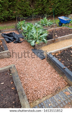 Installing weed control membrane or fabric and gravel pathway in a garden in England, UK Royalty-Free Stock Photo #1653511852