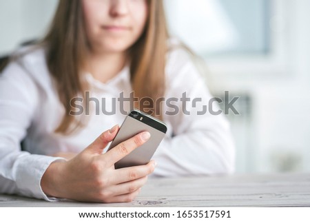 Close up of women's hands holding cell telephone. Typing write message on smart phone