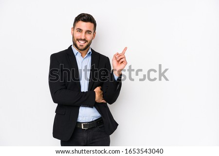 Young caucasian business man against a white background isolated smiling cheerfully pointing with forefinger away.