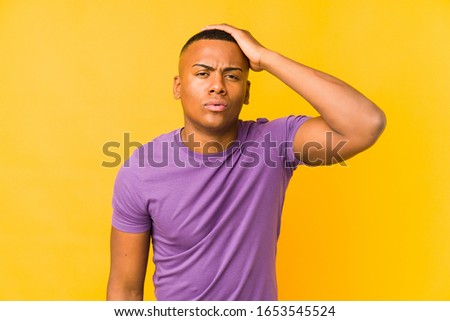 Young latin man isolated on yellow background tired and very sleepy keeping hand on head.